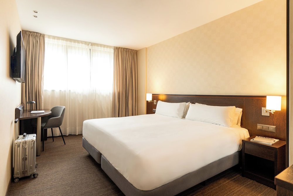 Modern guest room at Hotel Lugano Barcelona with large bed and work desk