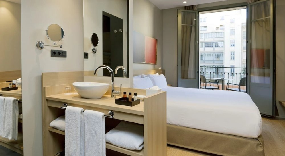 Bright hotel room at Hotel Àmbit Barcelona with balcony and city view