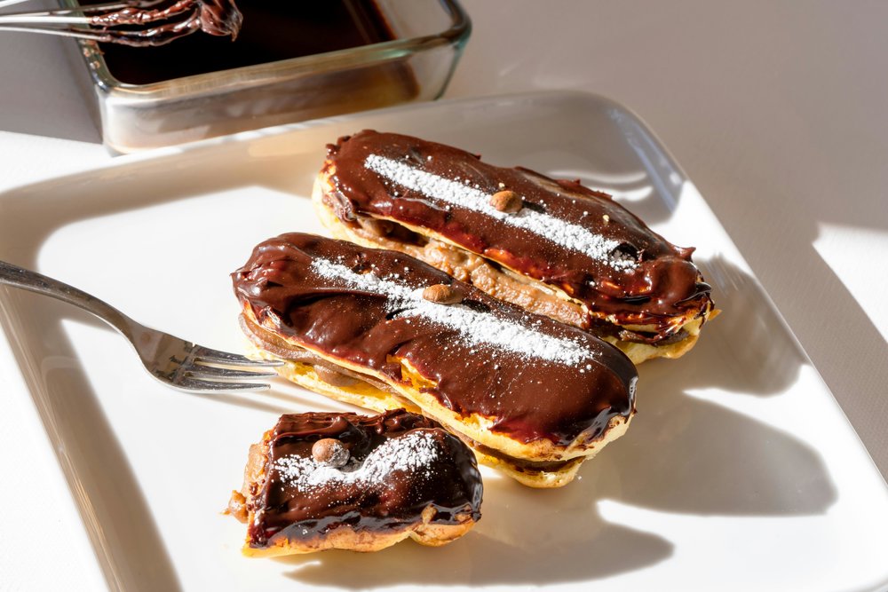 French chocolate éclairs served on a white plate