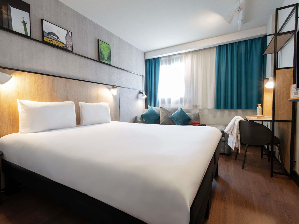 A cozy and stylish hotel room at Ibis Paris Gare de Lyon, featuring modern decor and amenities