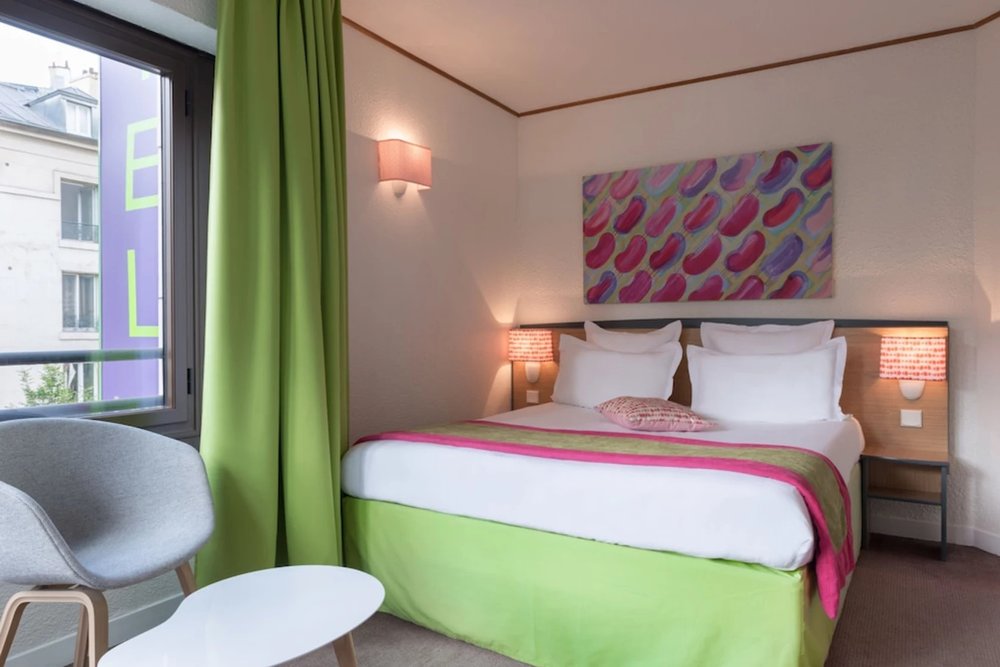 A minimalist room at Hotel Paris Louis Blanc, designed for comfort and convenience