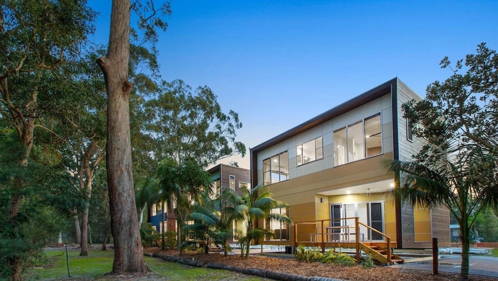  NRMA Holiday Park cabin surrounded by greenery and clear skies