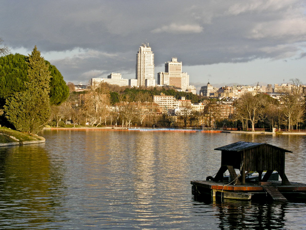 Lake view at Casa de Campo Park in Madrid with city skyline in the background | Photo Credit: Wikimedia Commons