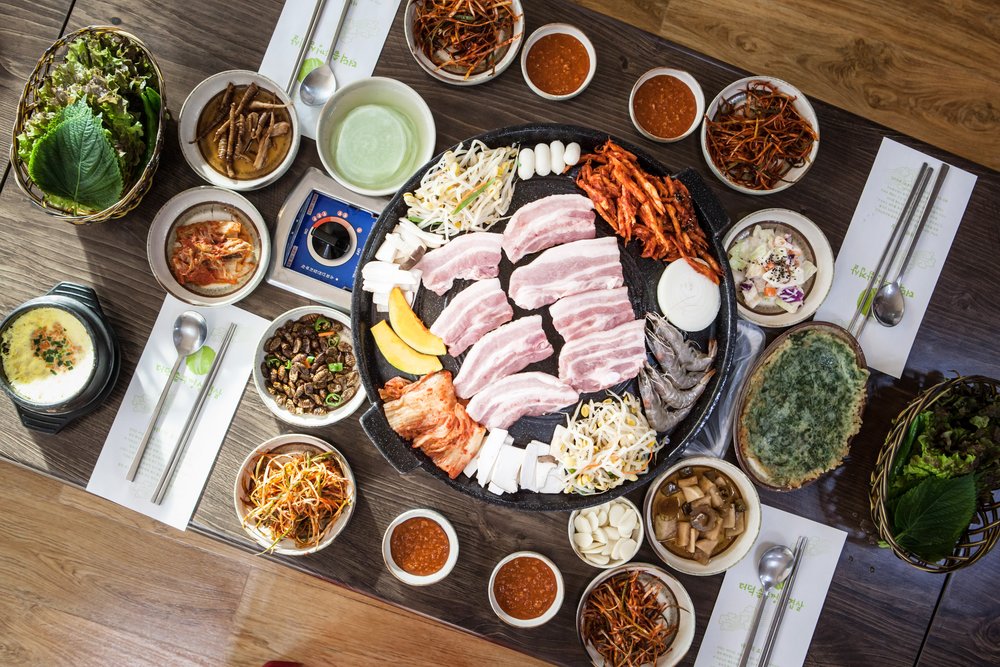 Grilled pork belly with side dishes and dipping sauces | Photo Credit: Wikimedia Commons