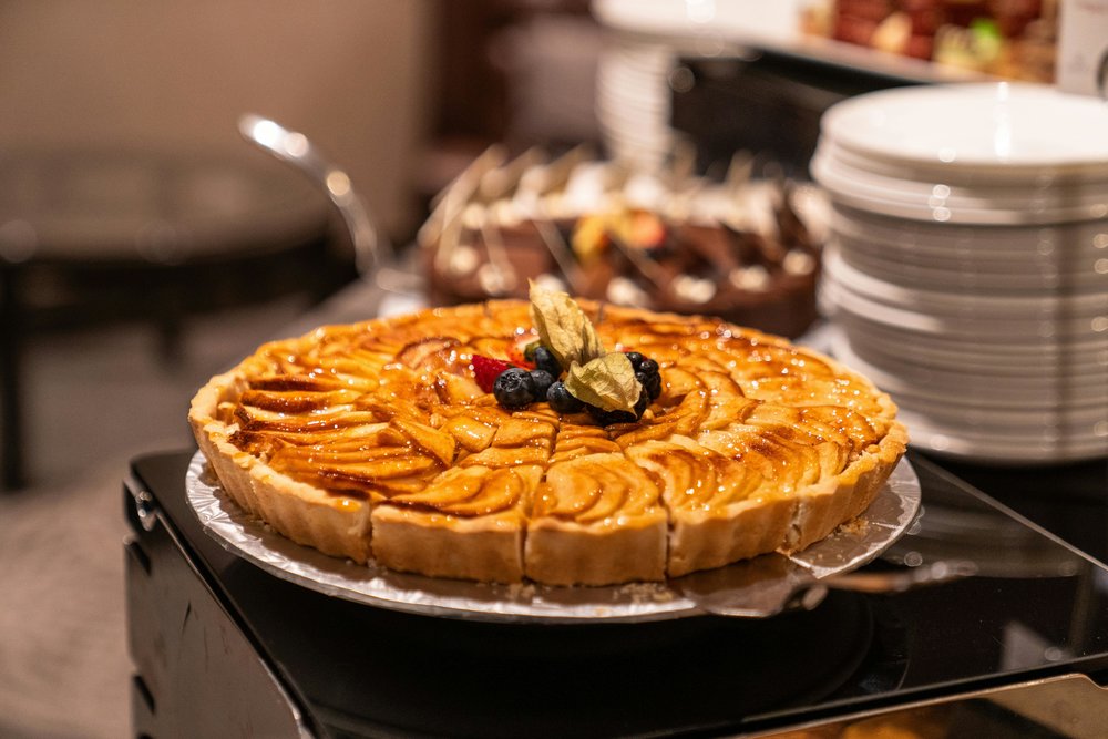 Caramelized apple French tart displayed on dessert table