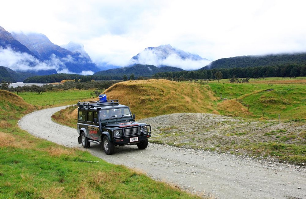 Off-road vehicle touring green valleys and mountains near Queenstown, New Zealand