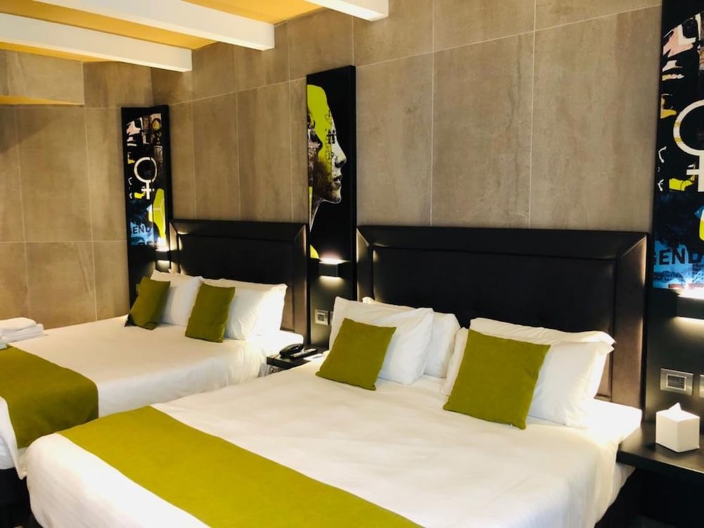 Modern twin bedroom with green accents at Just Hotel Milano Milan