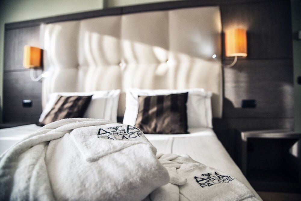 Comfortable double bed with bathrobes at Acca Palace Hotel Milan