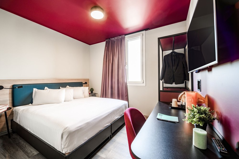 Modern double room at CX Venice Mestre hostel with desk and flat screen TV