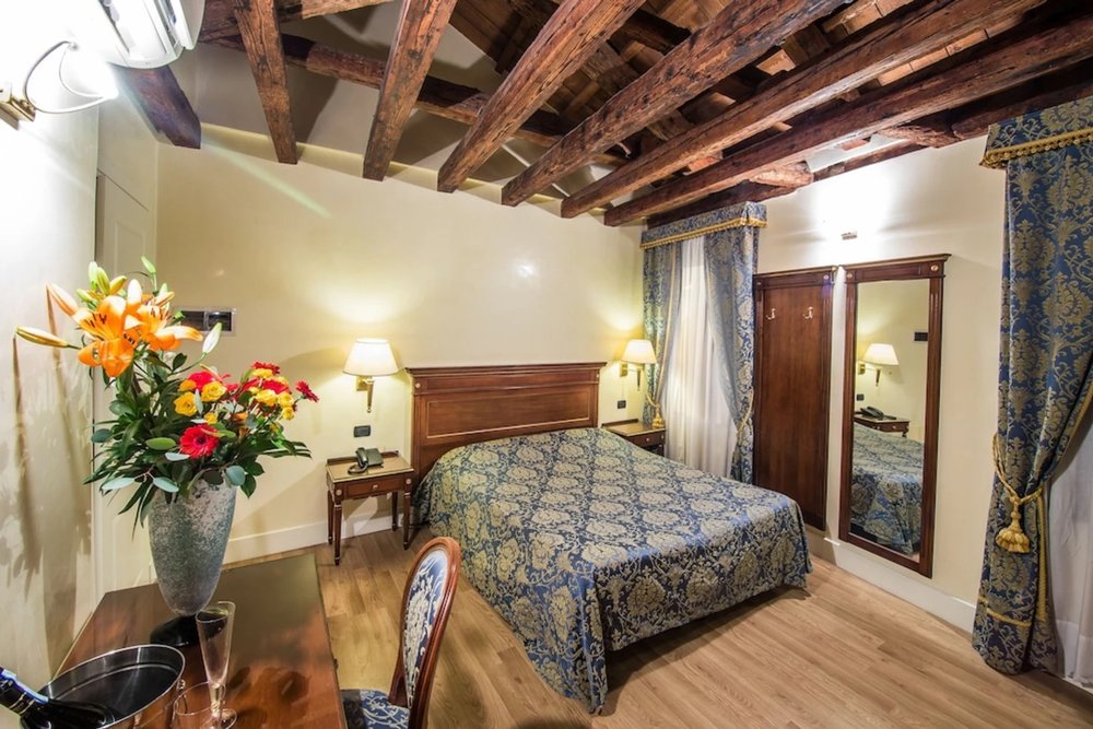 Cozy Venetian bedroom at B&B Le Marie with exposed wooden ceiling beams