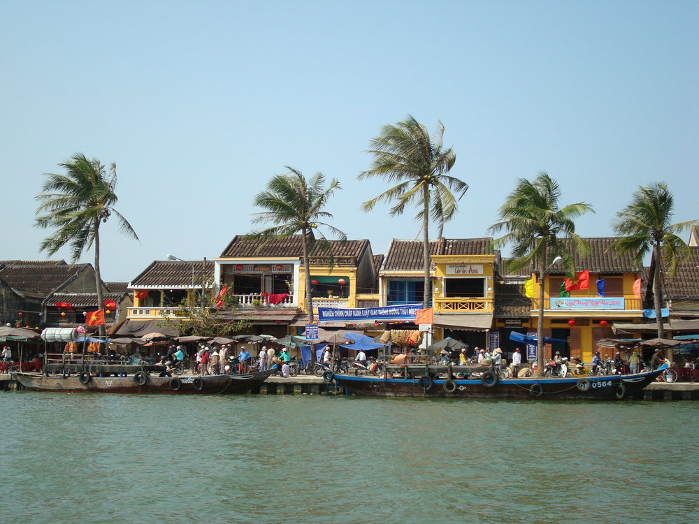 Boats along the Thu Bon River with Hoi An Ancient Town in the background | Photo Credit: Wikimedia Commons