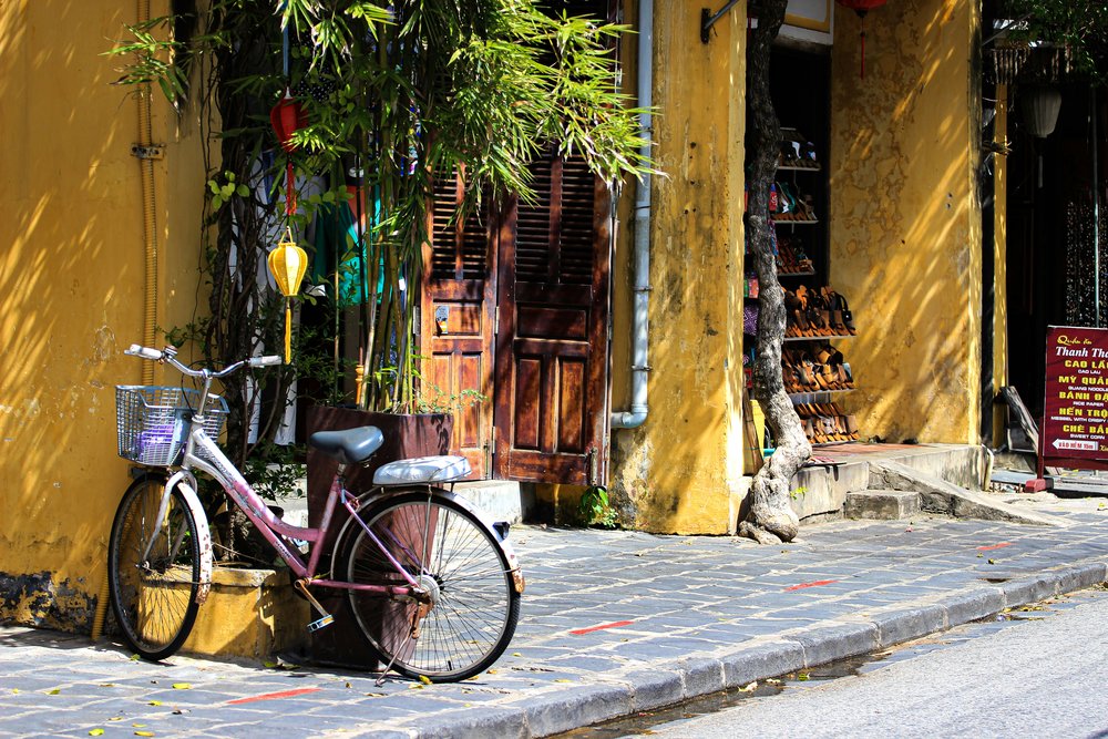 Yellow buildings and a bicycle along a street in Hoi An Ancient Town | Photo Credit: Max Do on Unsplash