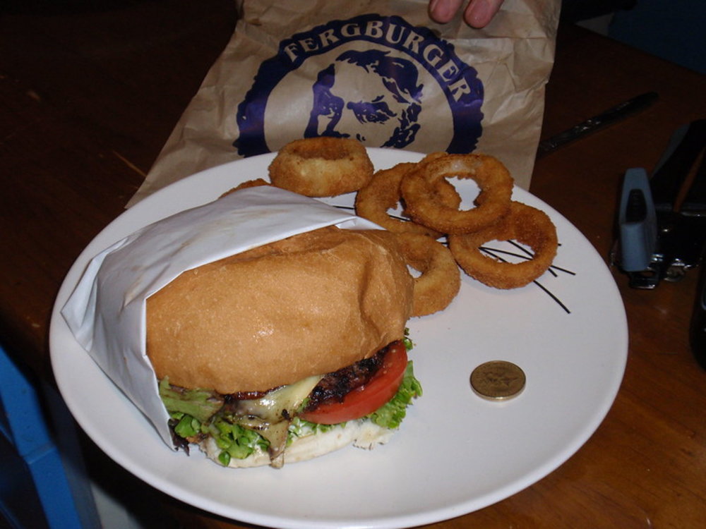 Large gourmet Fergburger with onion rings on plate