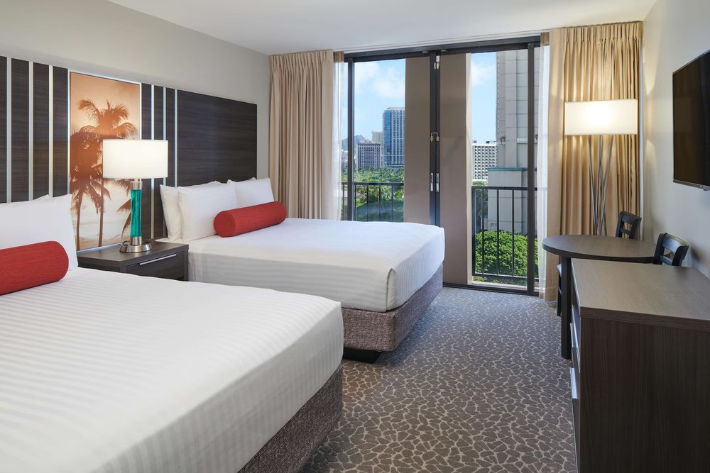 Guest room at Aqua Palms Waikiki with two beds and balcony view