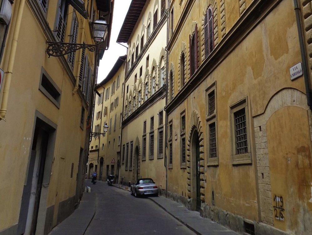 Narrow street in Florence's Oltrarno district, lined with historic buildings