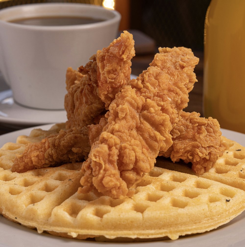 Fried chicken served on golden waffles with coffee and juice