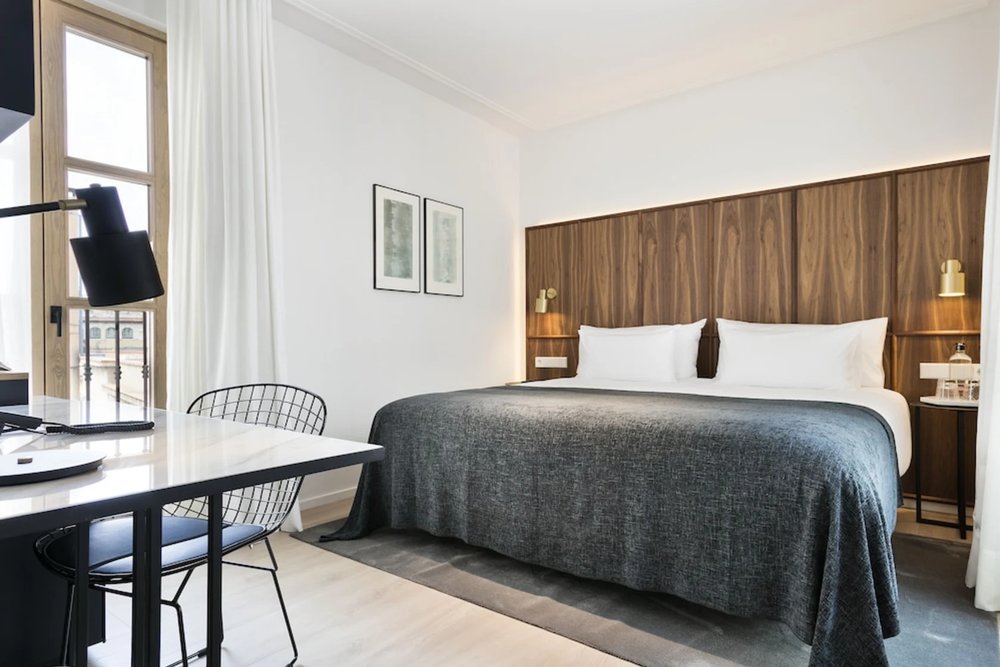 Yurbban Passage Hotel Barcelona bedroom with modern wood headboard and city view