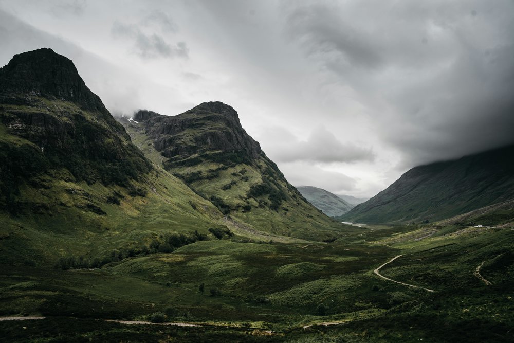 Scenic landscape of the Scottish Highlands with lush green hills and dramatic clouds