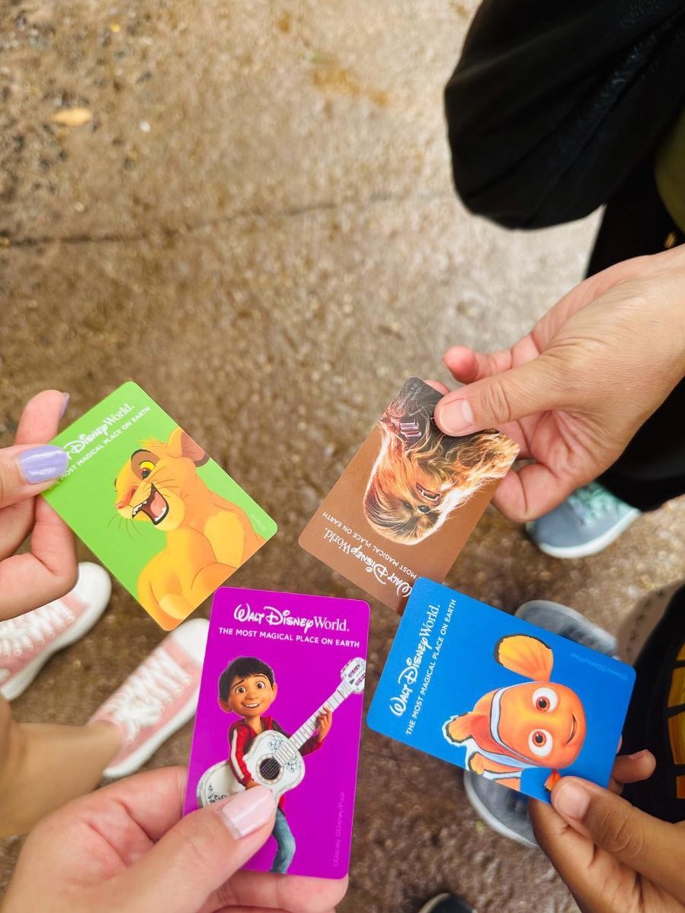 Hands holding Walt Disney World attraction passes Orlando