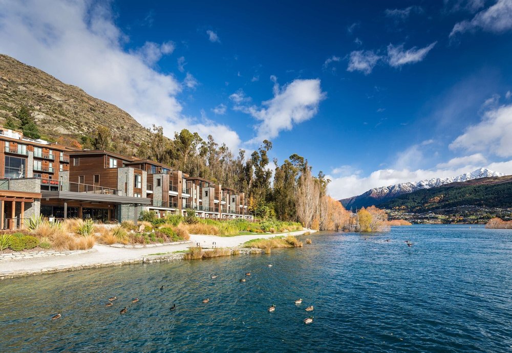 Hilton Queenstown Resort & Spa by Lake Wakatipu with mountains in the background