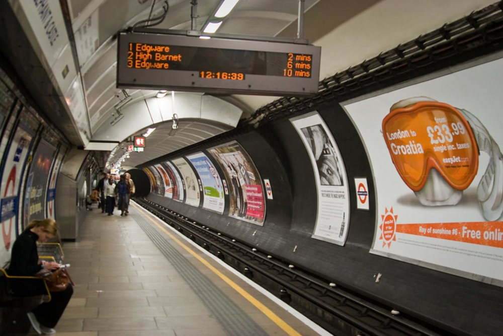 Inside the London Underground station showing train arrival times and platform
