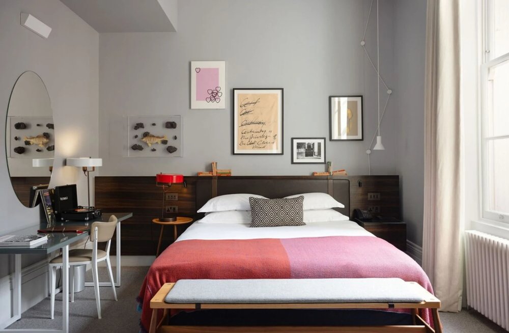 Modern hotel room with creative artwork and sleek design, featuring a comfortable bed