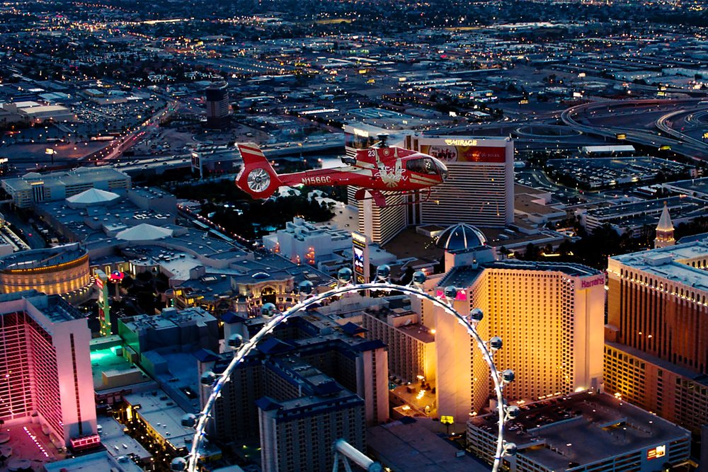  Helicopter flying over the Las Vegas Strip at night with city lights below