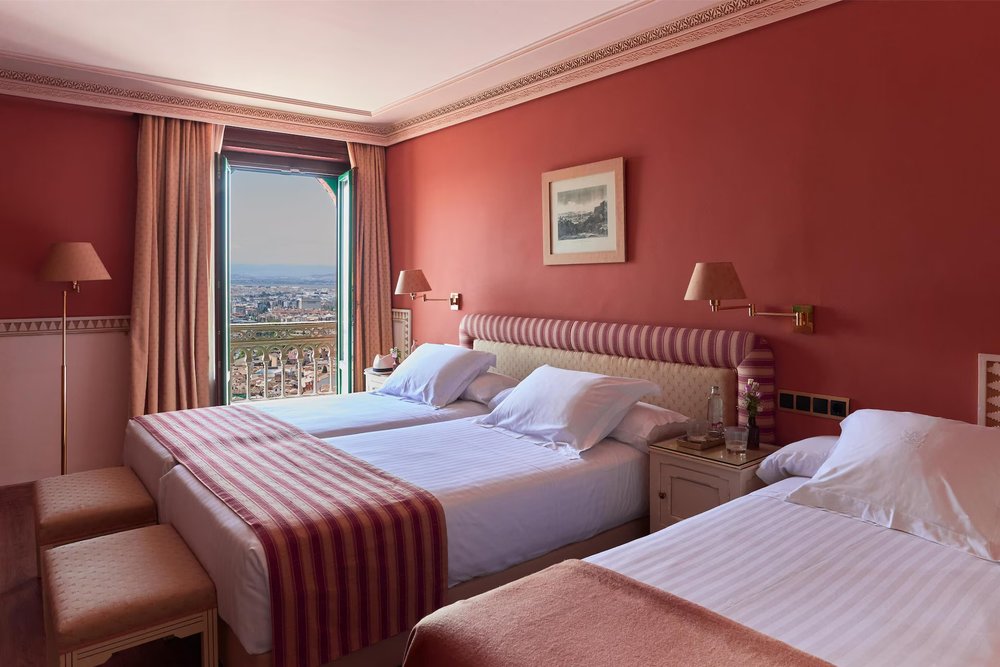 Classic luxury suite with ornate details and views of Granada at Hotel Alhambra Palace