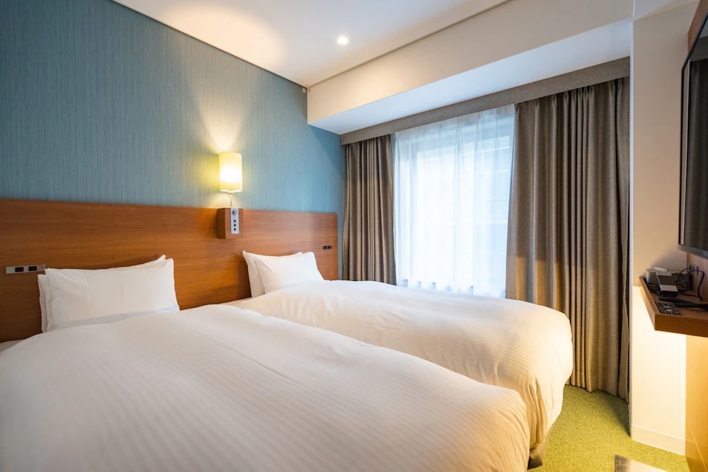 Minimalist twin beds at Prince Smart Inn Yodoyabashi Osaka Japan