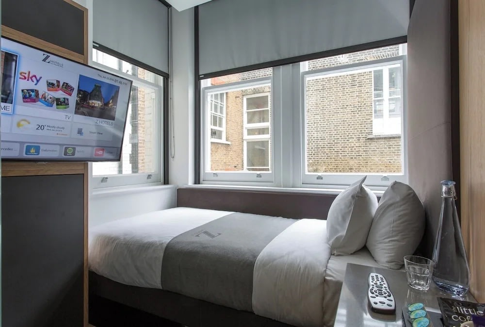 Modern and cozy room at The Z Hotel Piccadilly with a bed, TV, and window views