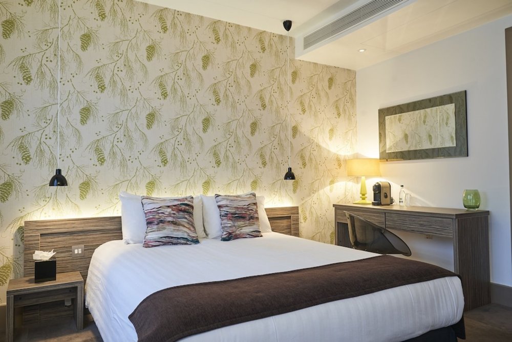 Elegant hotel room at Hotel Bosco with cozy bedding and modern decor