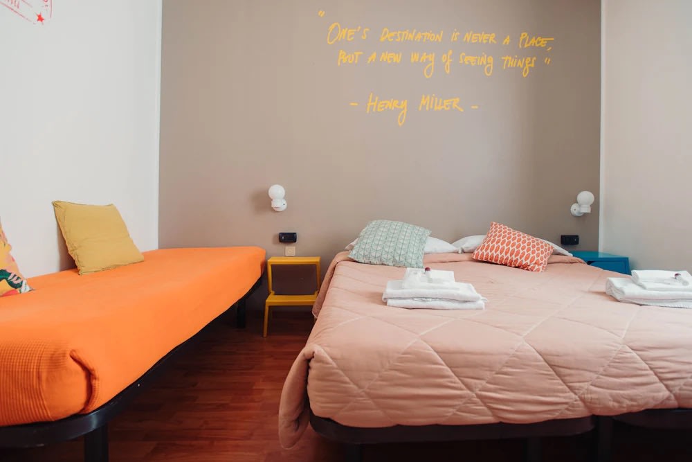 Bright shared room at Ostello Bello Milano Centrale with colorful beds and travel-inspired design