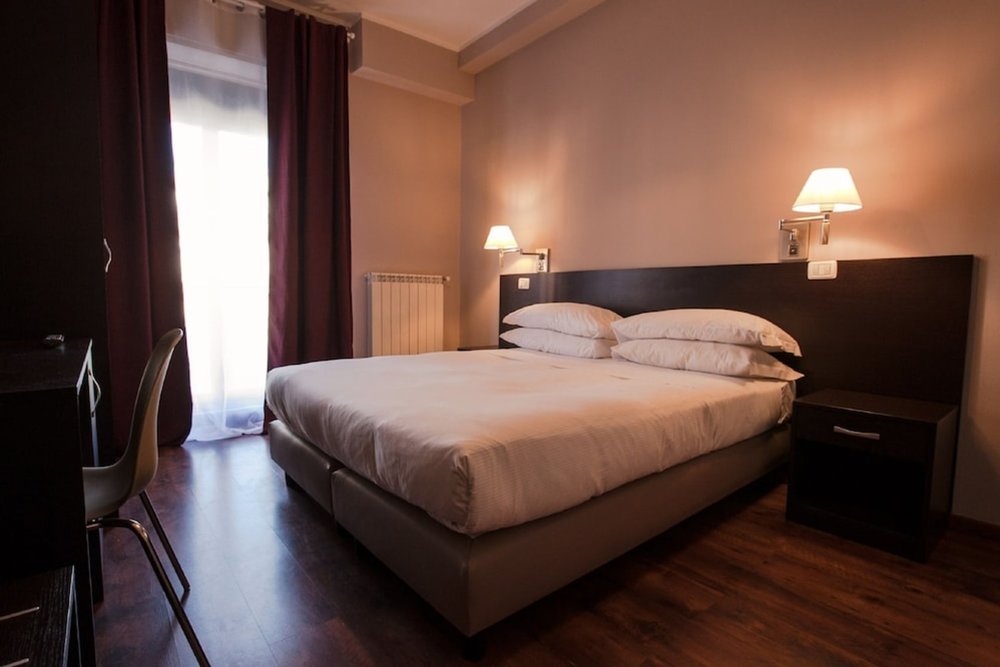 Warm and comfortable room at Hotel di Porta Romana with classic decor and soft lighting