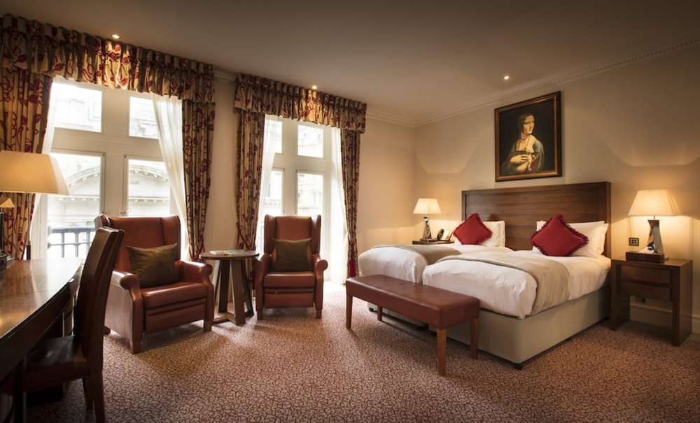 Family room at The Royal Horseguards, London, featuring elegant decor and a cozy atmosphere