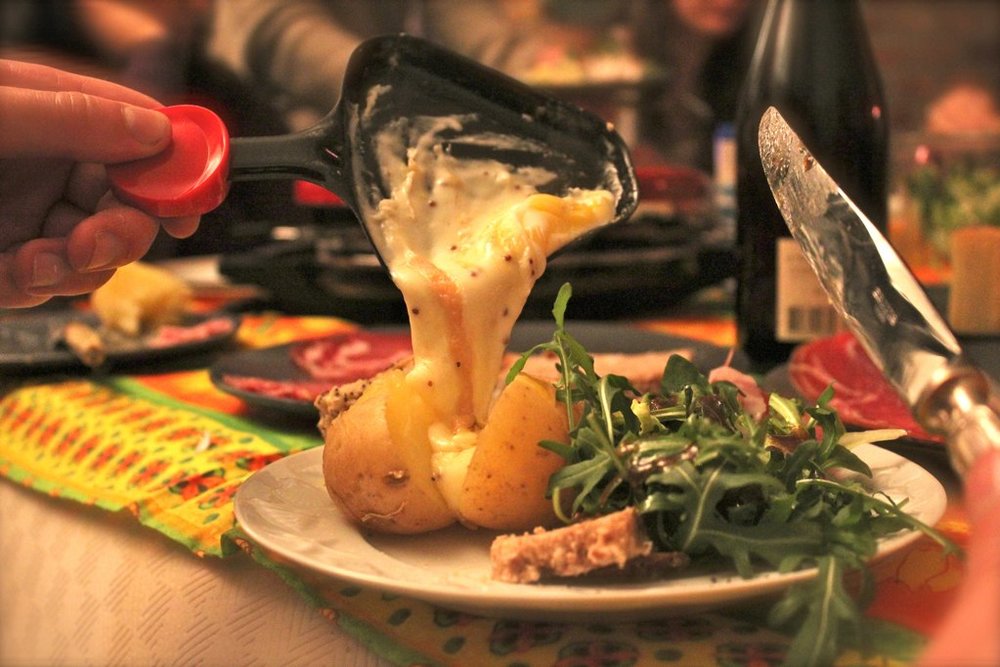 Raclette cheese melted over roasted potatoes | Photo Credit: Wikimedia Commons