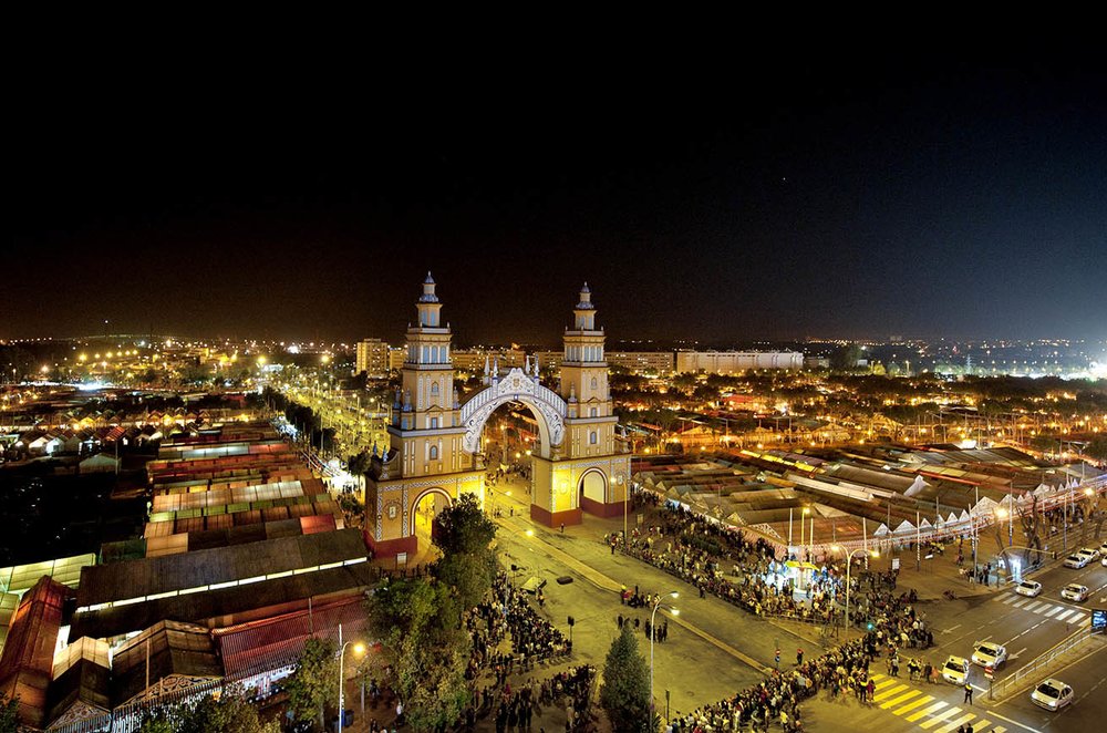 Seville Feria de Abril illuminated at night with colorful lights and crowds