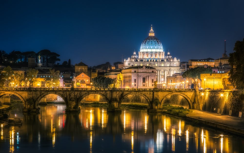 Night view of St. Peter's Basilica and the Tiber River in Vatican City