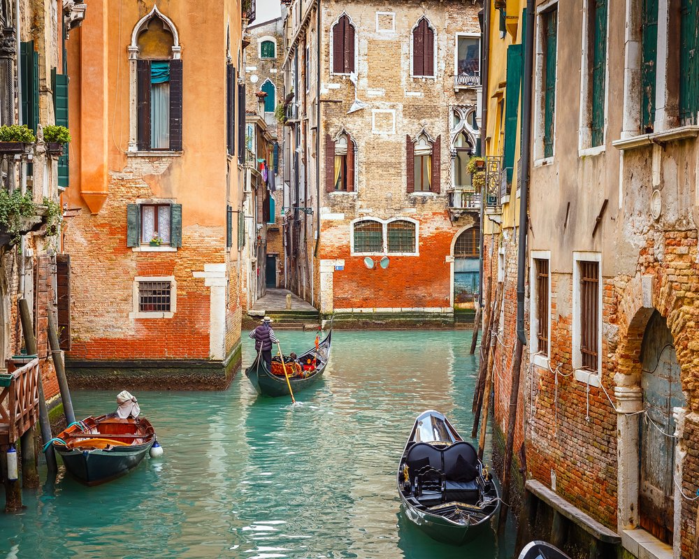 Gondola navigating the canals of Venice, with traditional Venetian architecture in the background