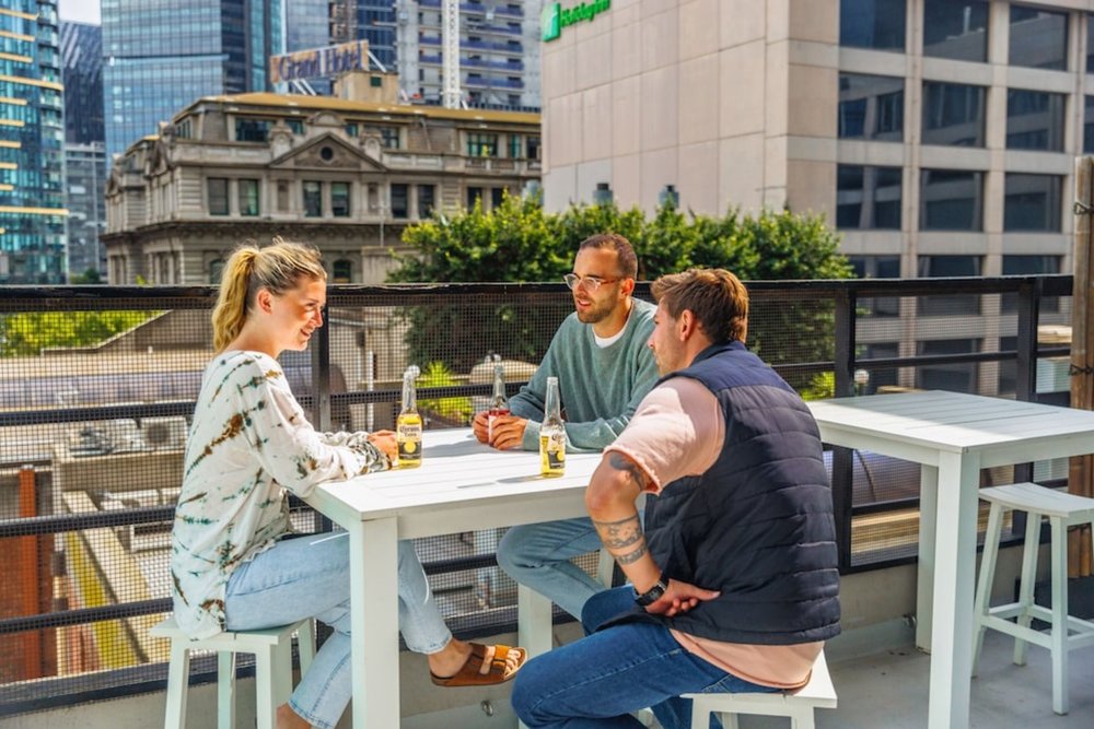Guests socializing on the rooftop terrace at YHA Melbourne Central hostel