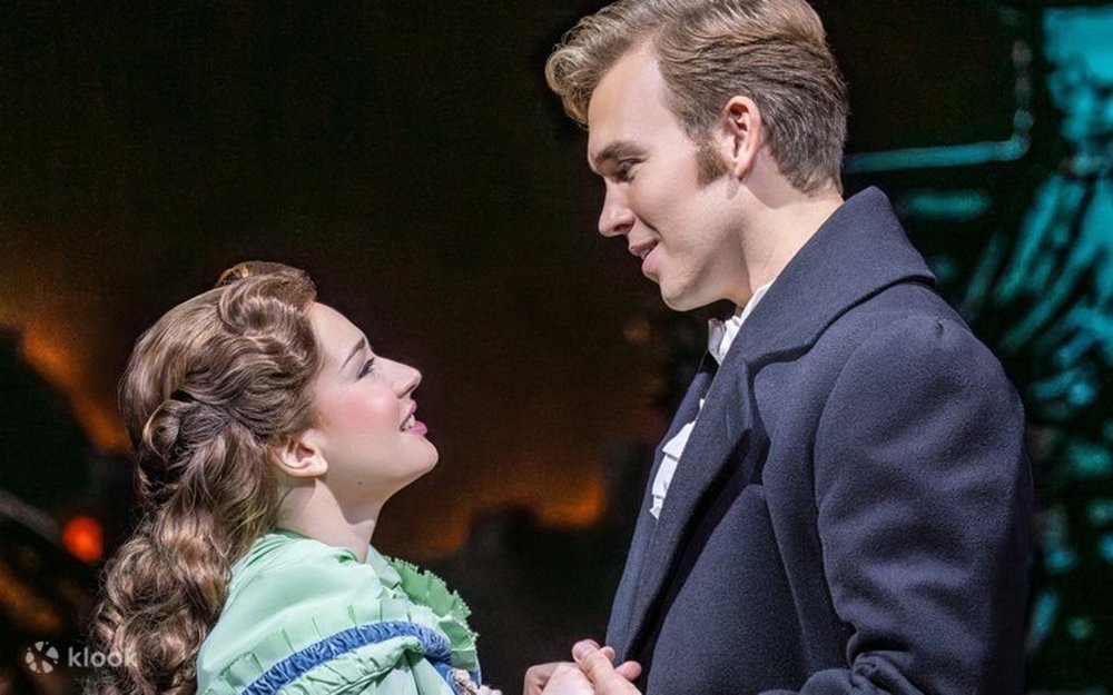 Two actors looking at each other lovingly onstage