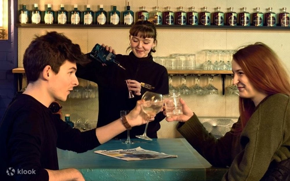 A bartender pours gin for a couple