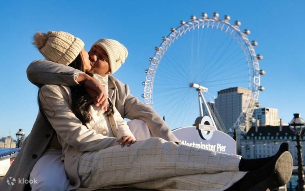A couple kissing with London Eye in the background
