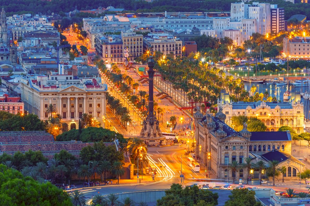 Barcelona skyline at night with Columbus Monument and glowing La Rambla