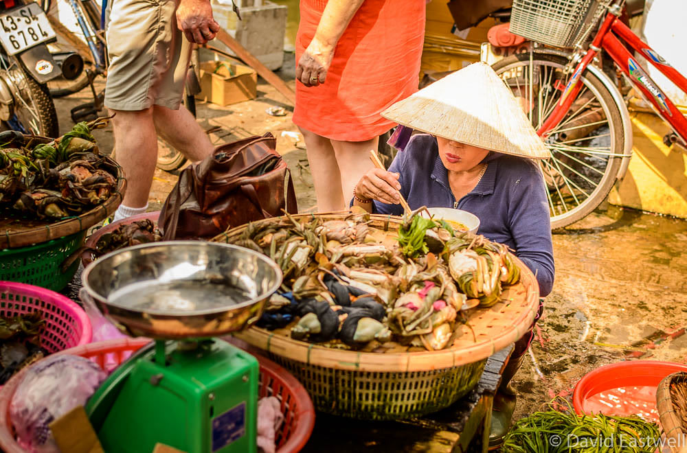 Vendor eating in a Hoi An market | Photo Credit: Flickr