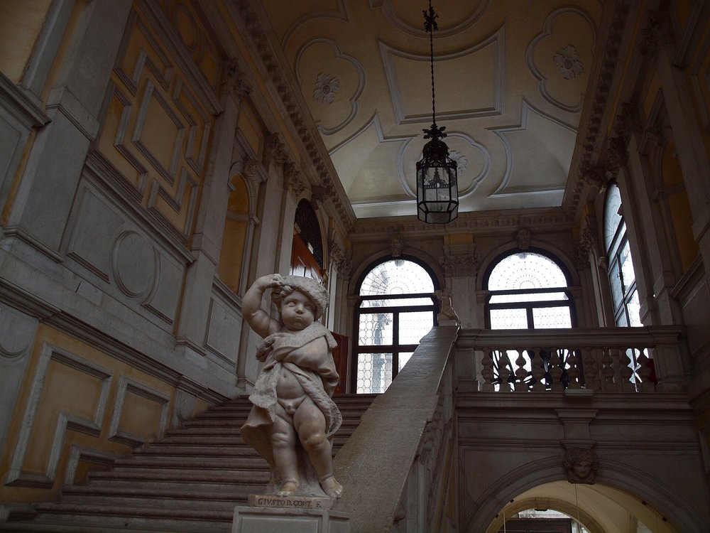A sculpture of a standing child on the staircase banister