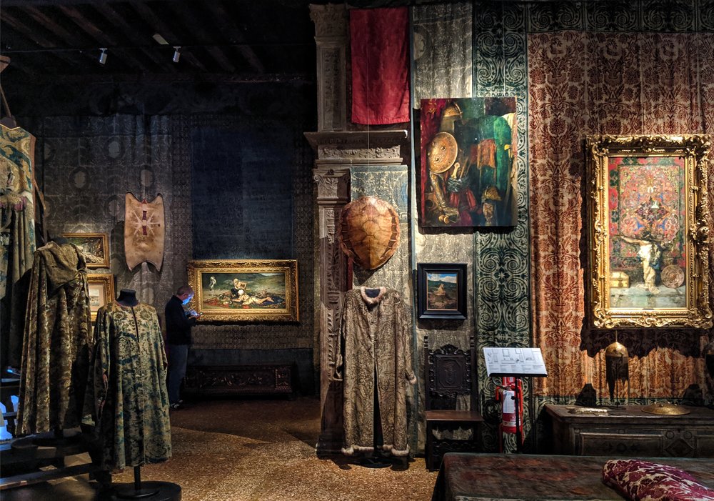 A room with prints on walls and clothes on display