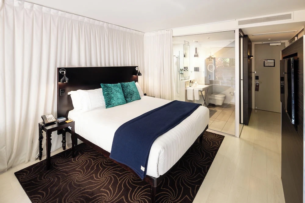 Modern suite at Queenstown Park Boutique Hotel with king bed and sleek glass bathroom