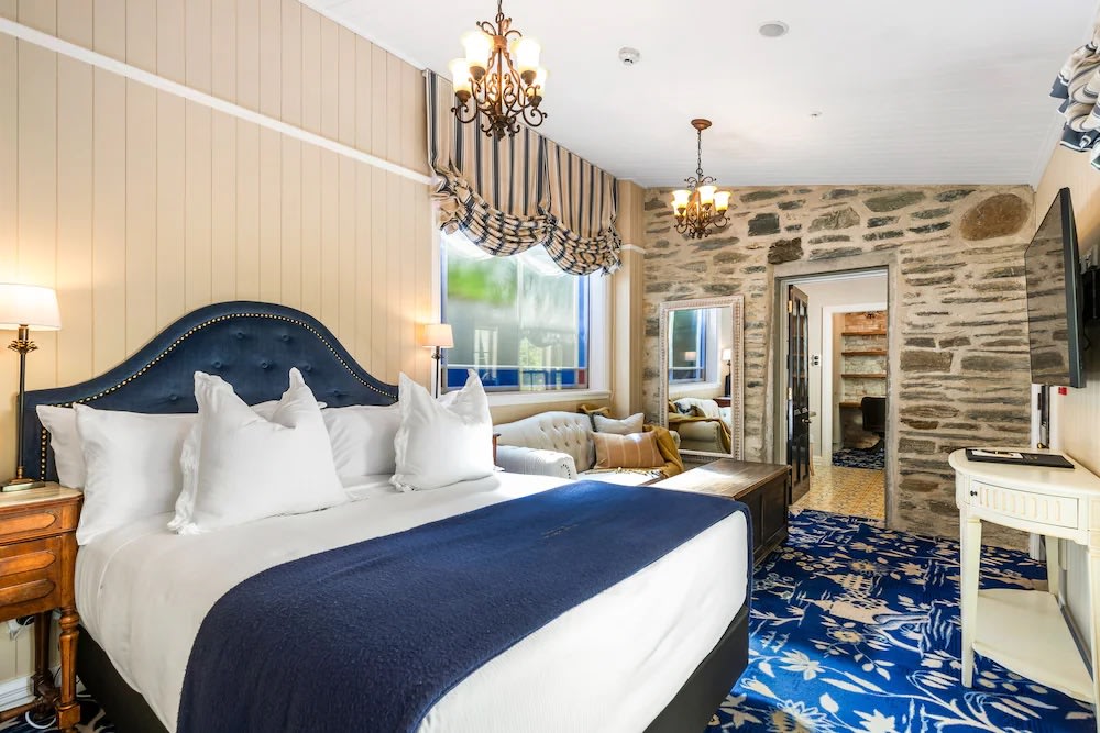 Elegant heritage suite at Hulbert House with plush king bed and stone wall details