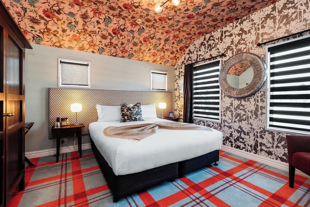 Charming room at The Dairy Hotel Queenstown with floral ceiling and cozy king bed