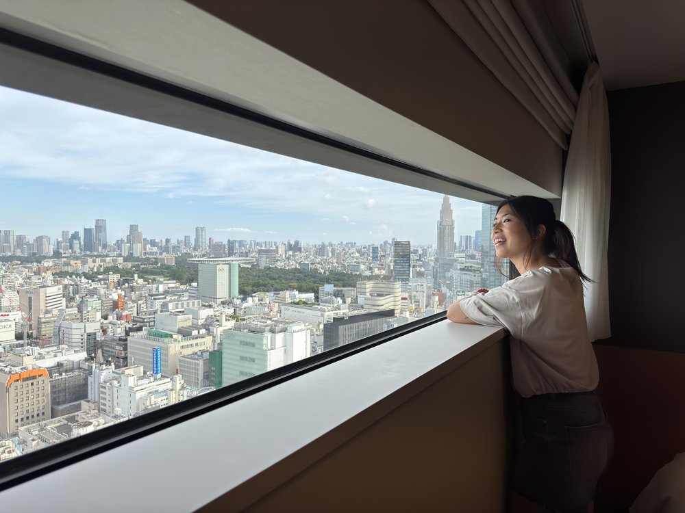 Woman looking out at Tokyo skyline from a hotel window